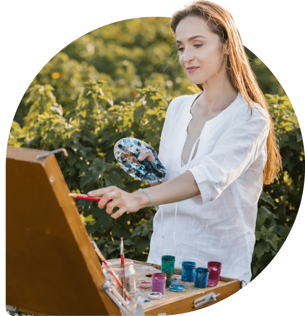 Eine Frau malt im Freien und lässt sich dabei von der Natur für zukunftsweisende Marketingideen inspirieren.