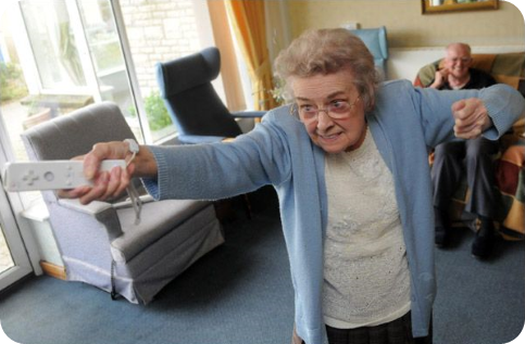 Ältere Frau, die im Altersheim Nintendo Wii spielt